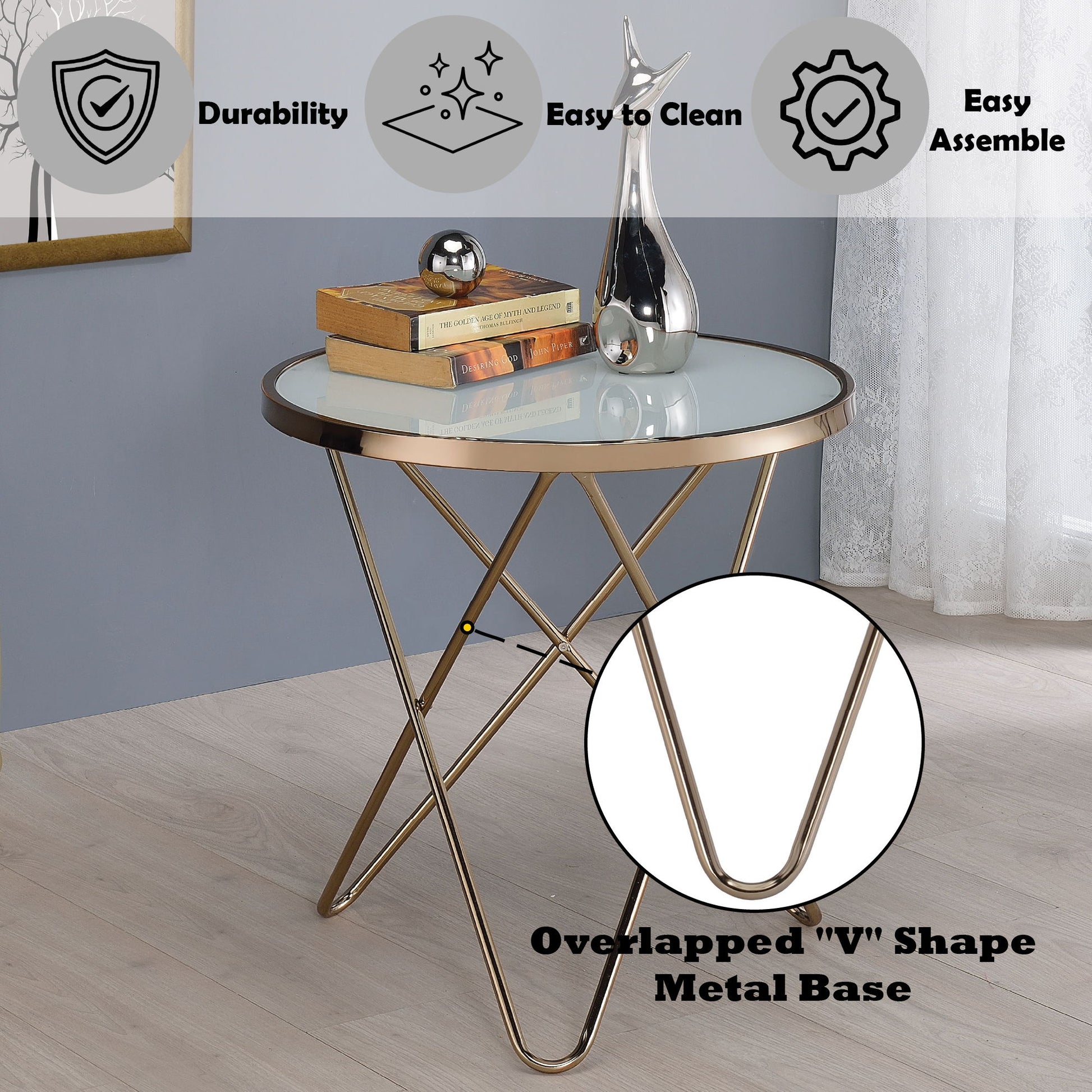 The Valora - Glass Coffee Table, with a round glass top and gold overlapped "V" metal base, sits in a modern room. Icons highlight its durability, easy-to-clean surface, and simple assembly. Decorative objects rest on the table.
