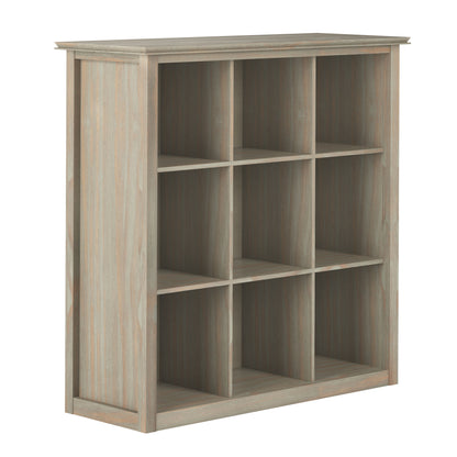 The Artisan - Cube Storage is a wooden bookshelf with a light, weathered finish, featuring nine square cubby holes in a 3x3 grid and boasting a simple, modern design.