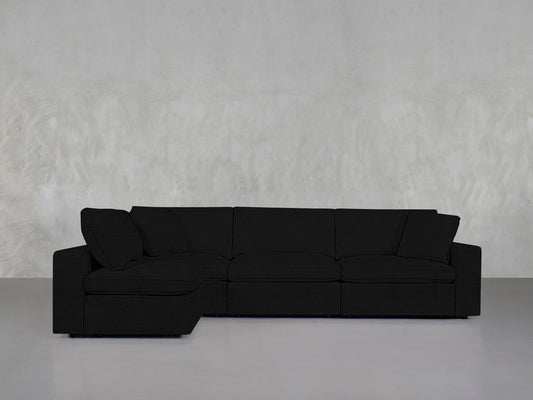 A 4-Seat Modular Open Corner Sectional with a left-facing chaise sits against a light gray textured wall and smooth gray floor in a minimalist room.