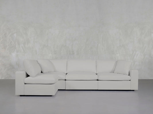 A 4-Seat Modular Open Corner Sectional in light gray, featuring clean lines and soft cushions, is set against a textured pale gray wall in a minimalist room with a smooth gray floor.