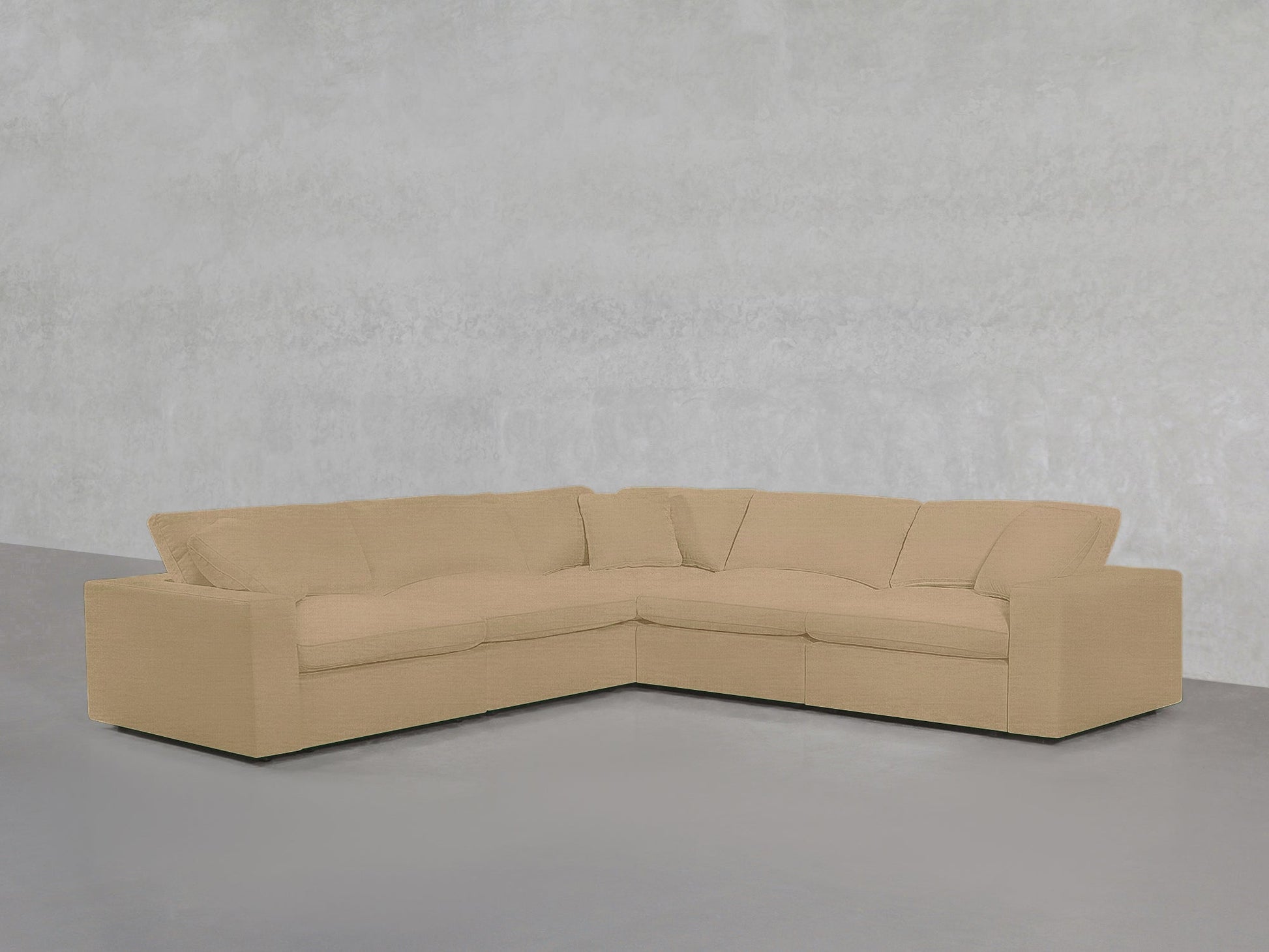 5-Seat Modular Corner Sectional with plush beige cushions, arranged in an L-shape against a plain light gray textured wall and floor.