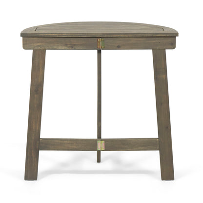 The Outdoor Half Round Folding Acacia Wood Bistro Table features a sturdy acacia wood build with a dark, rustic finish and visible grain, reinforced by metal brackets for extra durability and folds for easy outdoor storage.