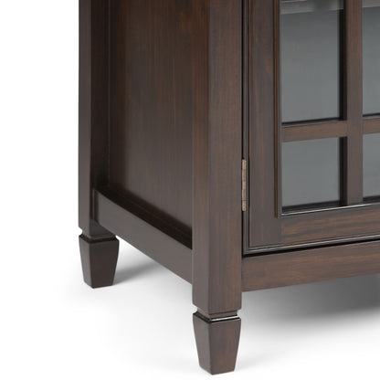 Close-up of the Connaught Handcrafted Low Storage Cabinet’s bottom corner, highlighting its dark brown wood, glass panel door, tapered legs, and smooth polished finish.