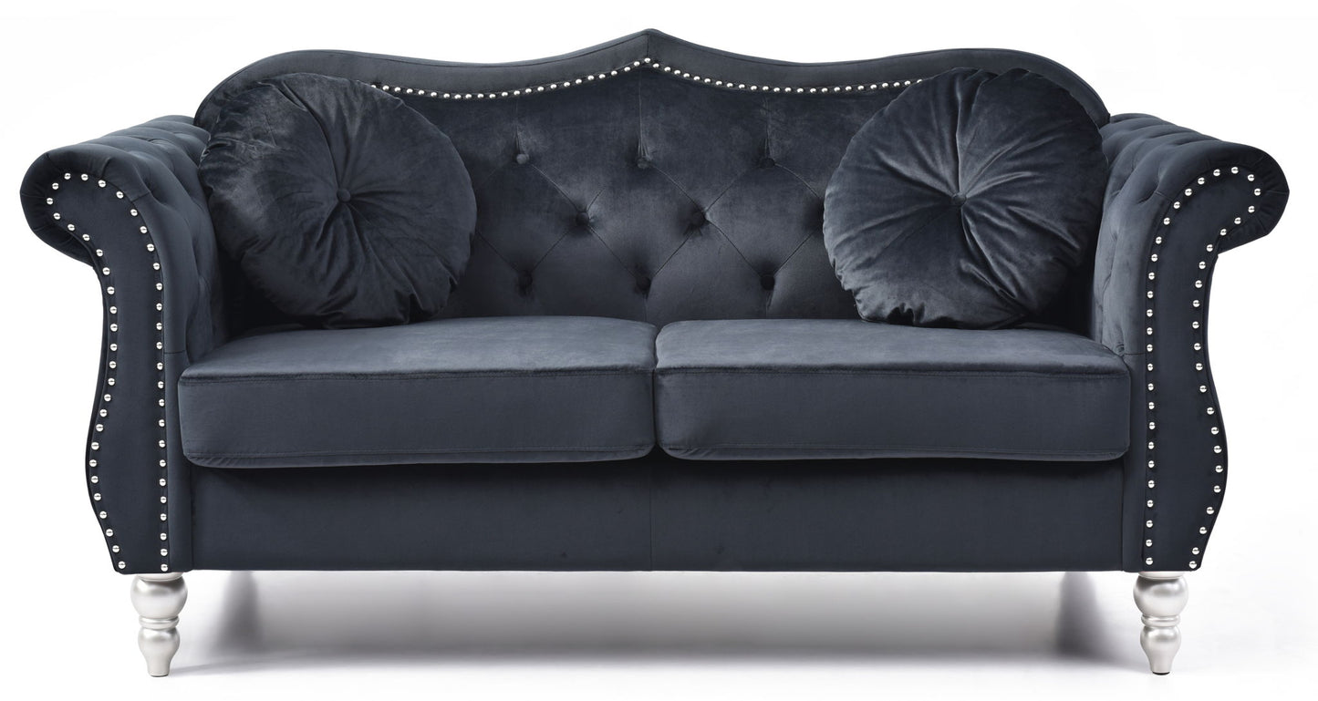 The Stylish Flared Arm Loveseat features a dark velvet finish, silver stud trim, tufted back, two round pillows, and silver legs, shown against a white background.