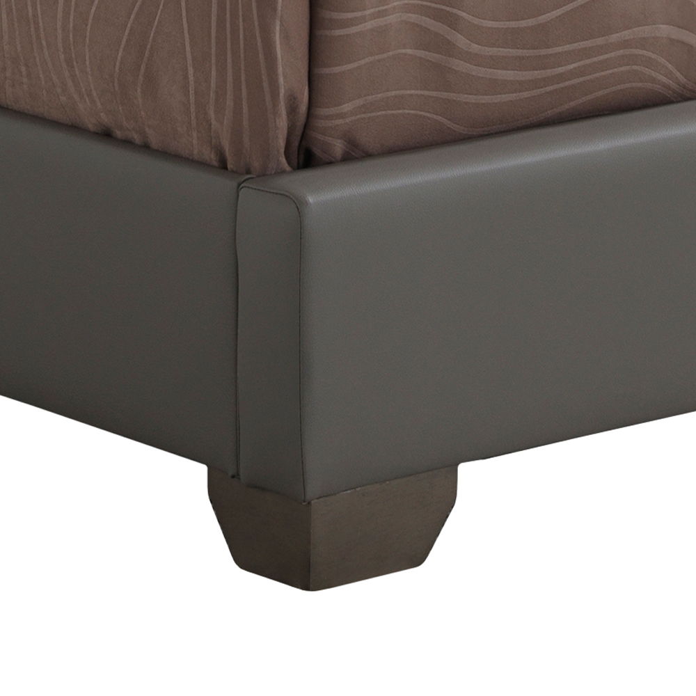 Close-up of the Elegant Platform Bed For Relaxed Spaces shows a gray upholstered frame corner with a brown mattress, patterned bedding, and a sturdy block-style wooden leg at the bottom.