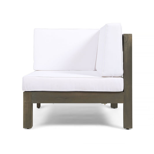 The Oana Arm Chair is a modern outdoor sectional piece featuring a dark wooden frame and thick white seat and back cushions, displayed on a plain white background.
