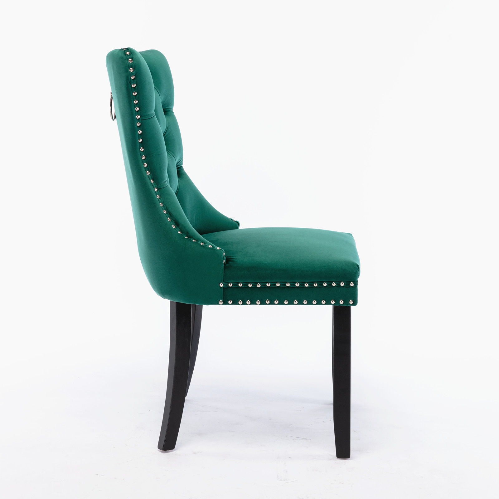 Side view of the Nikki modern dining chair set, featuring green velvet upholstery, button-tufted backrest, silver nailhead trim, dark wood legs, sleek design, and a chrome ring handle. Set includes two high-end contemporary chairs.