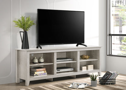 A flat-screen TV sits on the Benito TV Stand with open shelves holding books, decor, and a black vase with foliage; sunlight pours in from a nearby window.