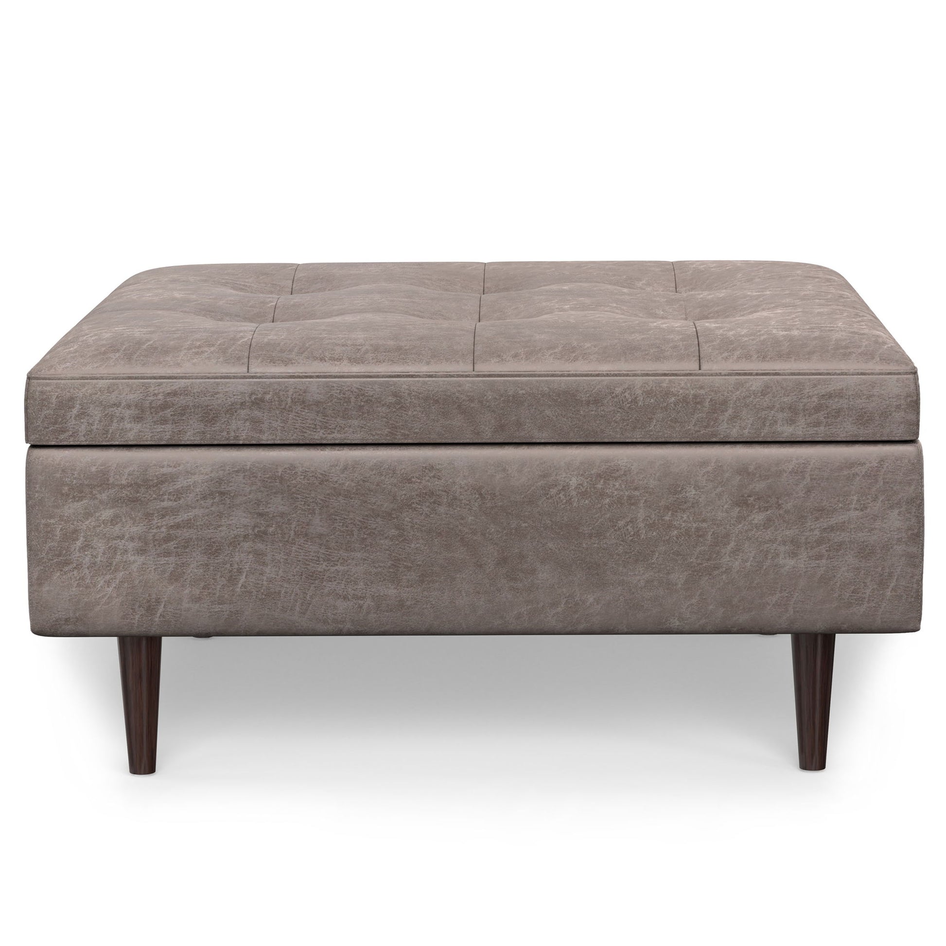 The Shay Large Square Coffee Table Storage Ottoman features light brown upholstery, subtle tufted top detailing, and four dark wooden legs in a mid-century style, displayed against a white background.
