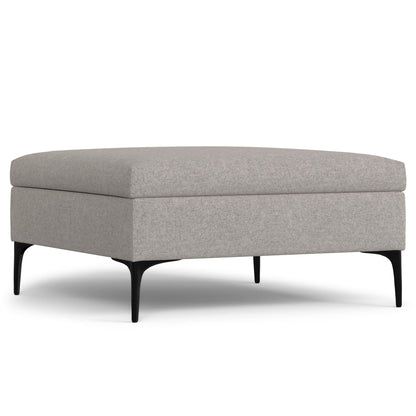 The Rebecca Multifunctional Coffee Table Storage Ottoman features a modern square design with light grey upholstery, black angled legs, and a lift-up lid, showcased on a white background.