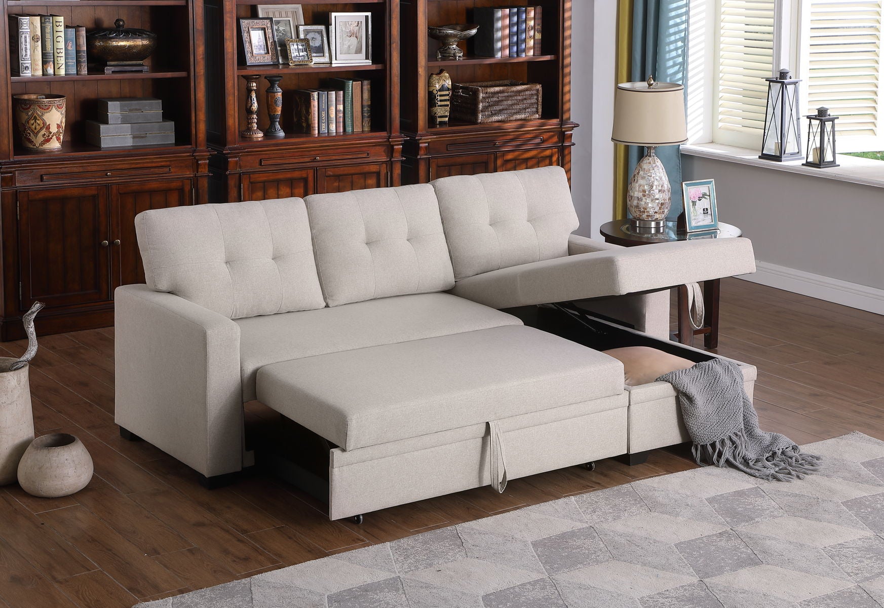 A Couch.com Replacement Armrest Beige with storage and fabric construction in a beige finish is in a living room with wooden floors, rug, bookshelves, and window. A gray blanket rests on the open storage compartment.