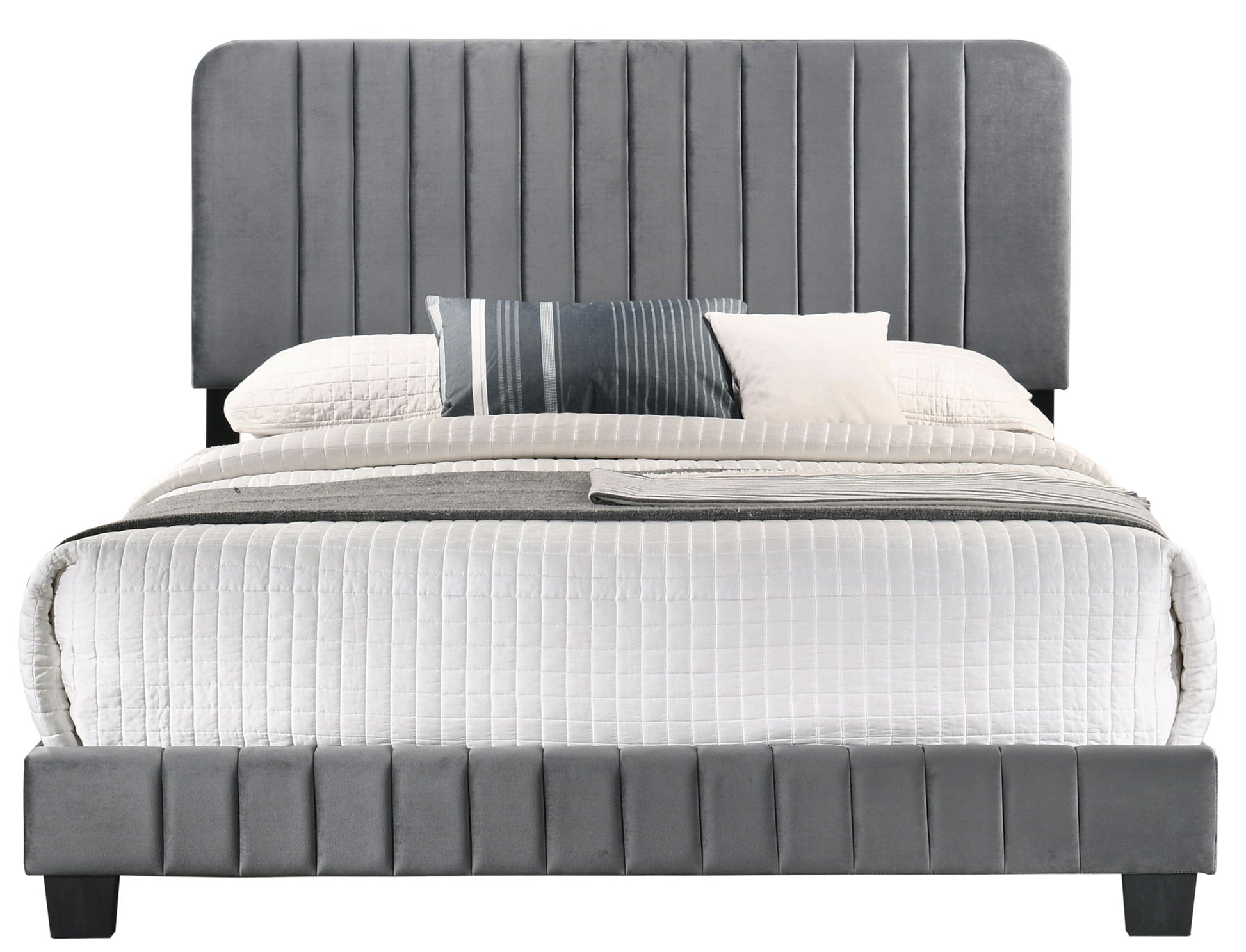 The Lodi - Bed features a modern, tall gray headboard with vertical stitching and a matching footboard. It is styled with white bedding, a gray blanket, and pillows in white, gray, and striped designs.
