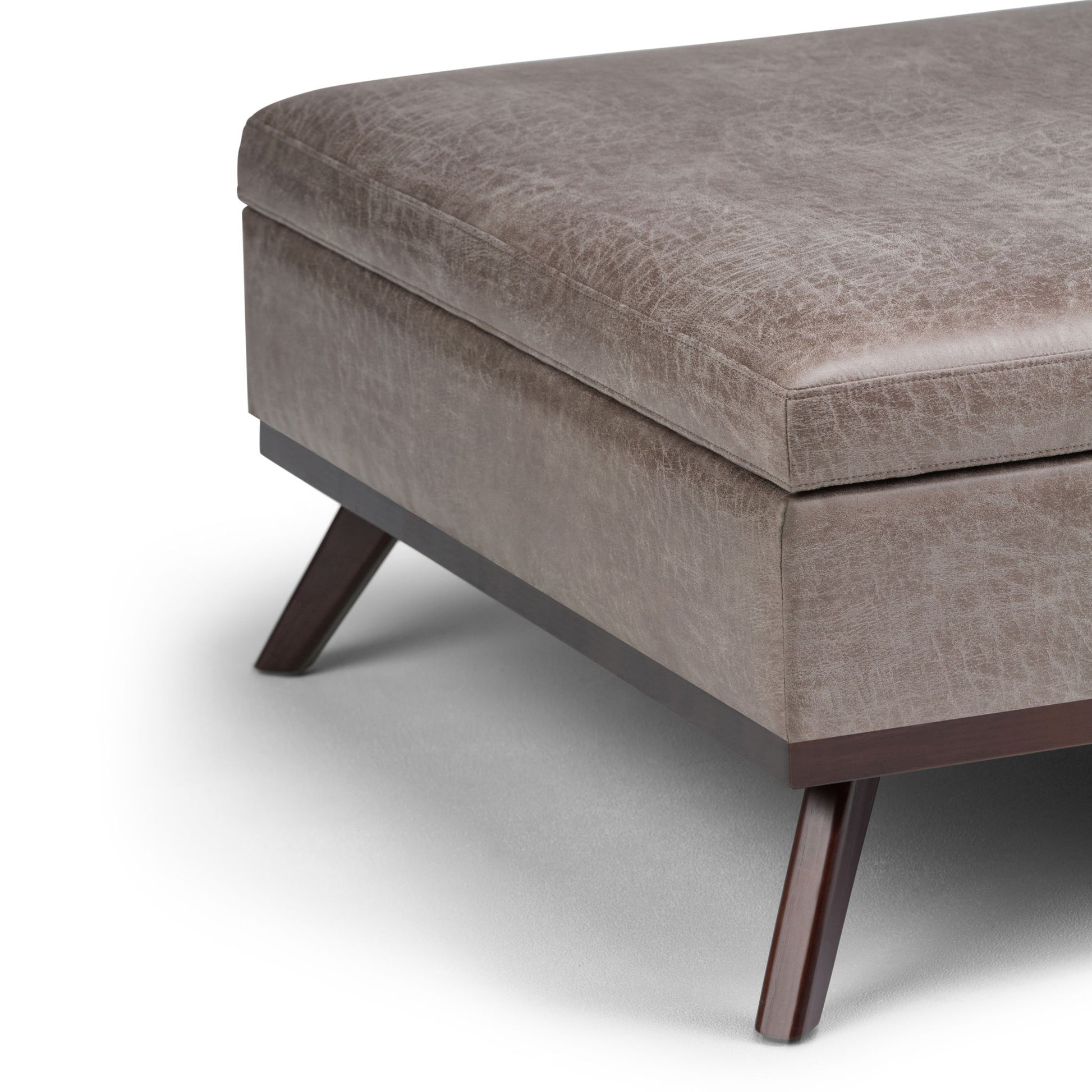 A close-up of the Owen - Multifunctional Square Coffee Table Storage Ottoman, featuring textured brown leather upholstery, wooden legs, and clean, angled lines set against a white background.