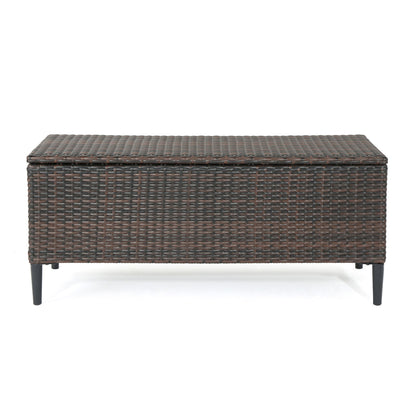 The Rupert Storage Unit is a rectangular resin wicker outdoor box in dark brown with a woven rattan design, hinged lid, and four black legs.