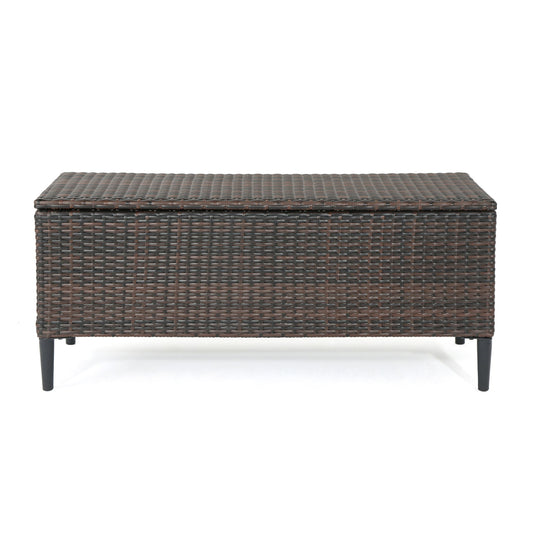 The Rupert Storage Unit is a rectangular resin wicker outdoor box in dark brown with a woven rattan design, hinged lid, and four black legs.