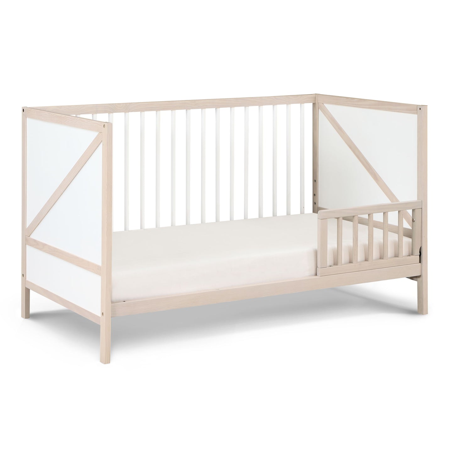 The Pixie Zen 3-in-1 Crib in Walnut features white panel accents, open slatted sides, and a partial safety rail on one side, displayed against a white background.