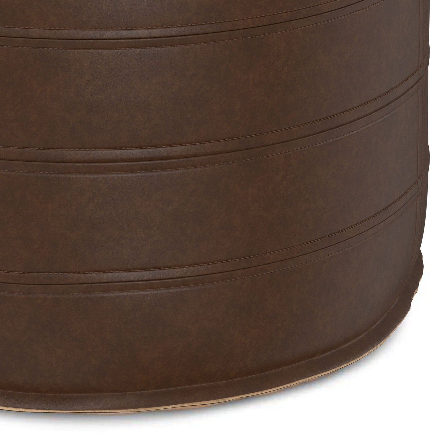 Close-up view of the Brody - Round Pouf, a brown, cylindrical seat featuring visible stitched horizontal seams. Upholstered in leather or faux leather with a smooth, subtly textured surface.