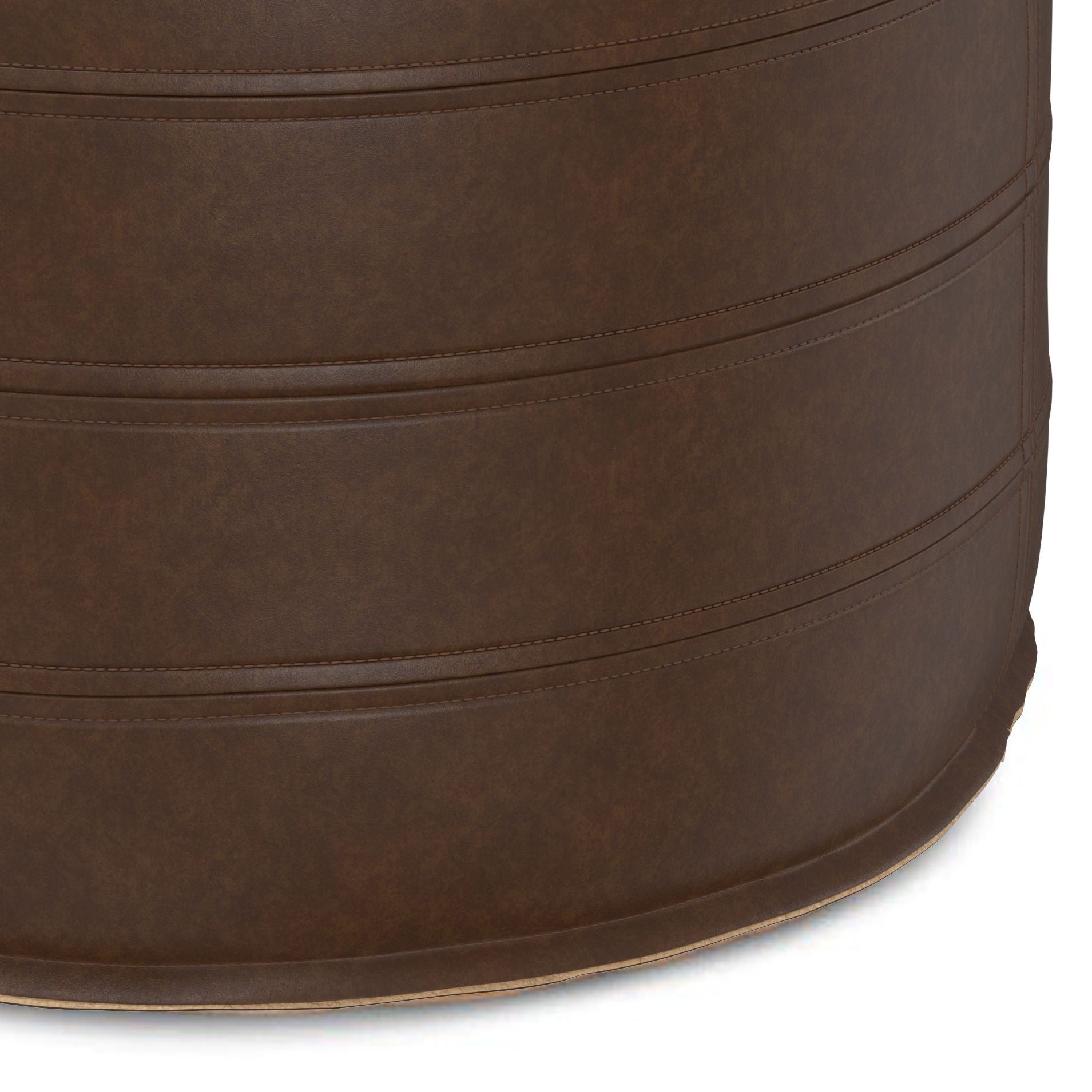 Close-up view of the Brody - Round Pouf, a brown, cylindrical seat featuring visible stitched horizontal seams. Upholstered in leather or faux leather with a smooth, subtly textured surface.