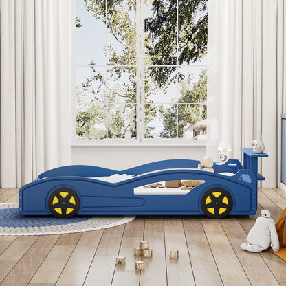A Wooden Race Car Bed, Car Shaped Platform Twin Bed With Wheels For Teens, stands in a bright children's room with stuffed animals, letter blocks, large windows with white curtains showing trees, and a round rug completing the cozy look.