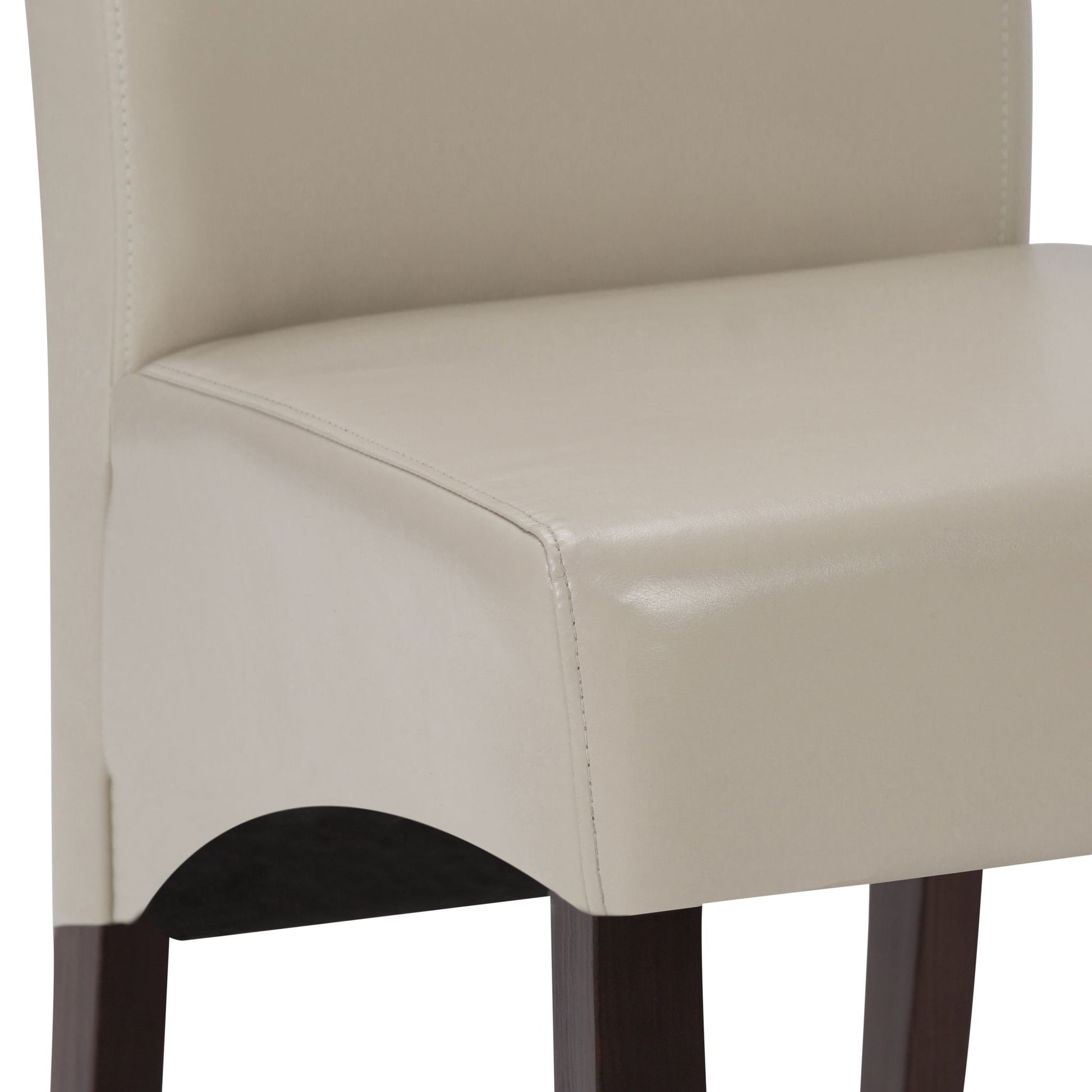 Close-up of the Avalon - Deluxe Parson Dining Chair (Set of 2) in beige upholstery with dark wooden legs. The seat's stitching and texture are clearly visible, featuring smooth lines and a gently curved edge.