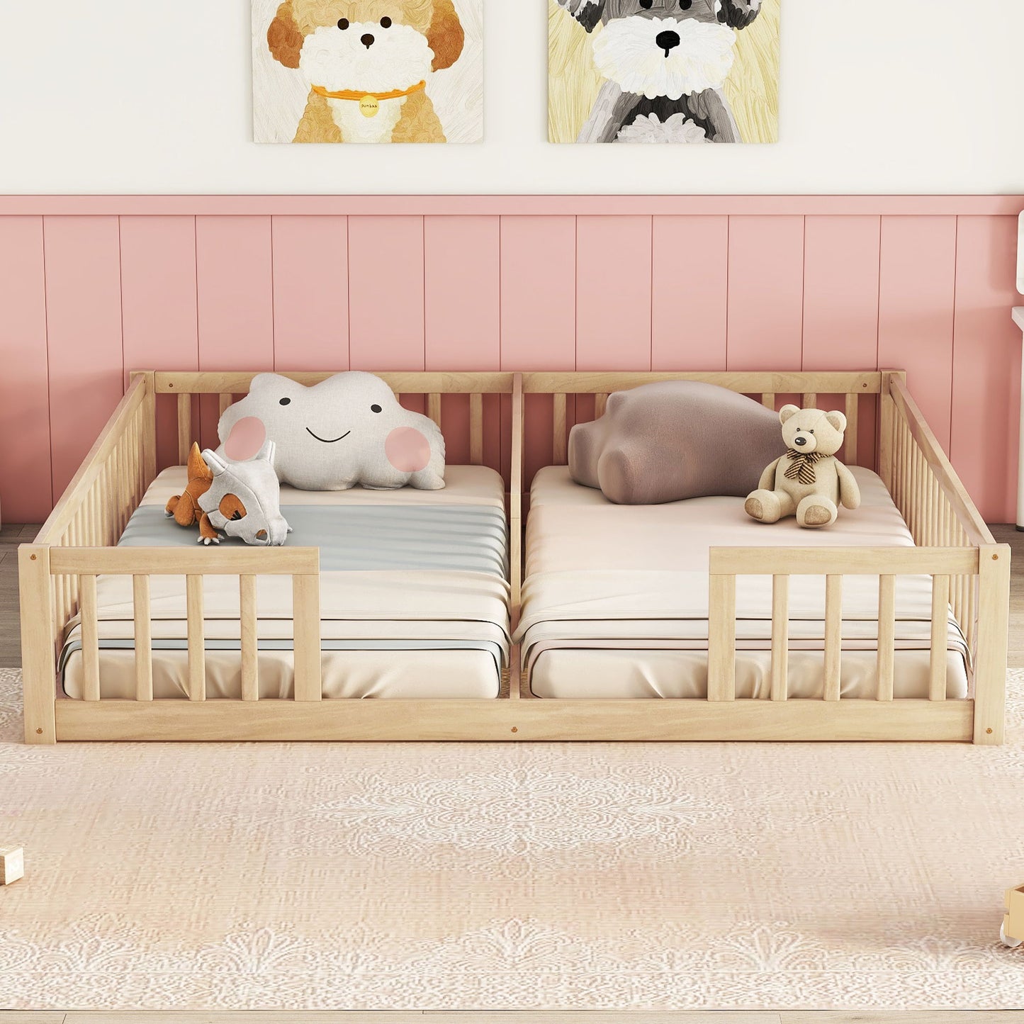 A Double Floor Bed With Fence and Guardrails (no door) holds two mattresses with soft toys like a teddy bear, plush cloud, and animal. The room features a pink wall and dog-themed artwork above the bed.