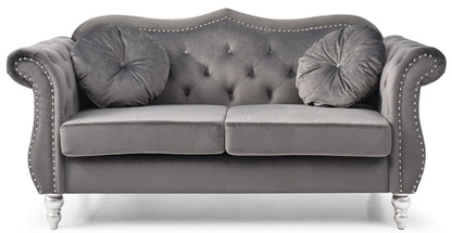 The Stylish Flared Arm Loveseat features a gray velvet finish, tufted backrest, silver nailhead trim, rolled arms, two matching round pillows, silver legs, and a classic, elegant design.
