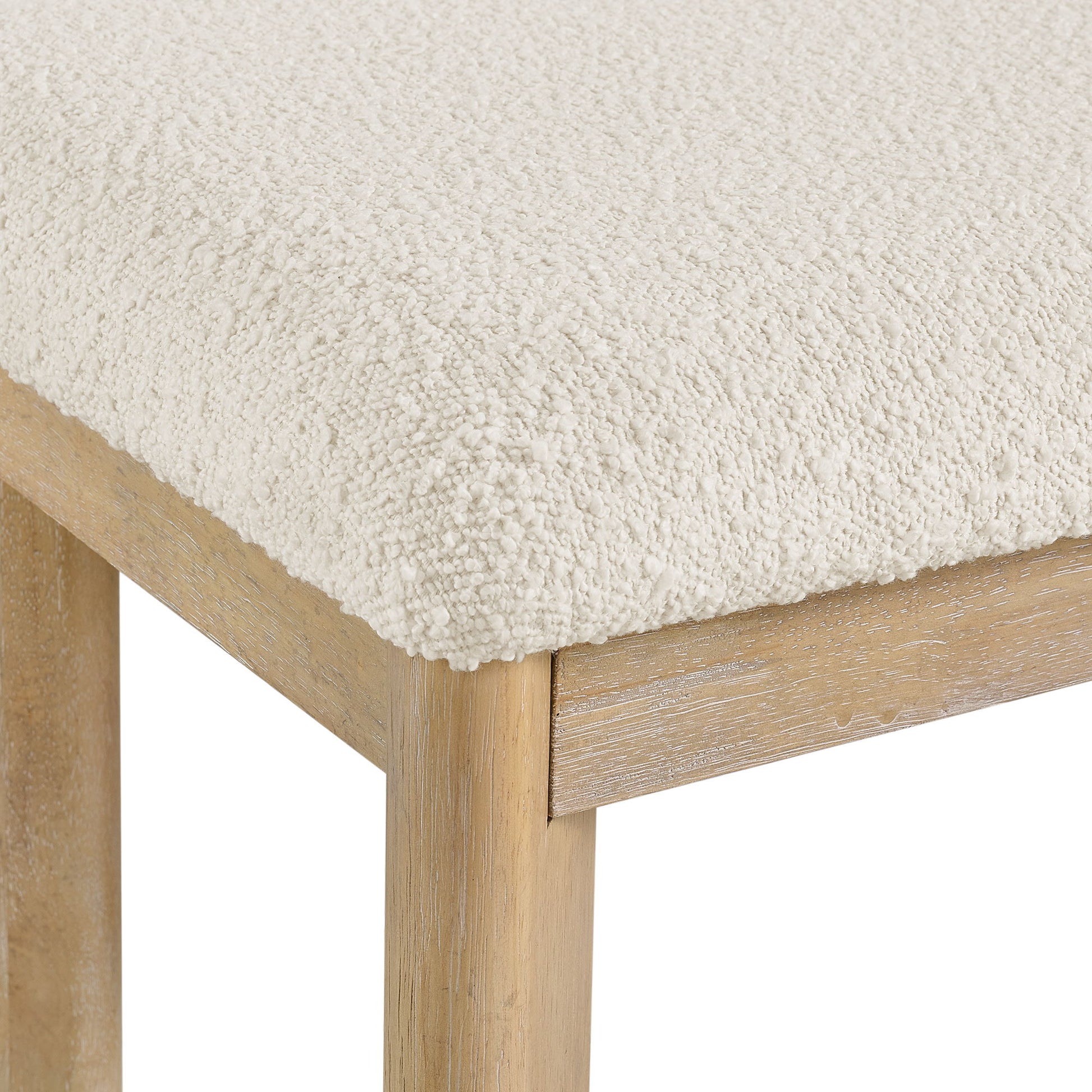 Close-up of the Clove Upholstered Dining Bench in brown, highlighting its textured seat and light wood legs with a natural finish.