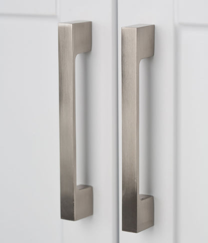 Two modern, rectangular brushed metal handles are mounted vertically on the white doors of the Hennessy - Deluxe Laundry Cabinet With Faucet And Stainless Steel Sink, positioned side by side.