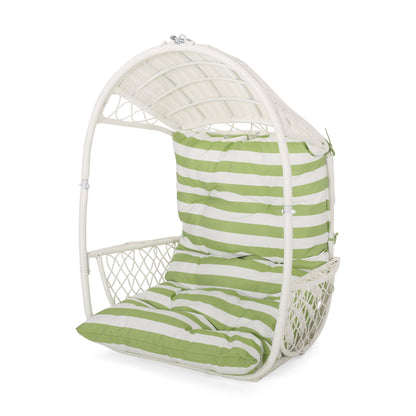 The Malia - Wicker Hanging Chair With Cushion is a white domed wicker chair featuring green and white striped cushions and a supportive backrest.
