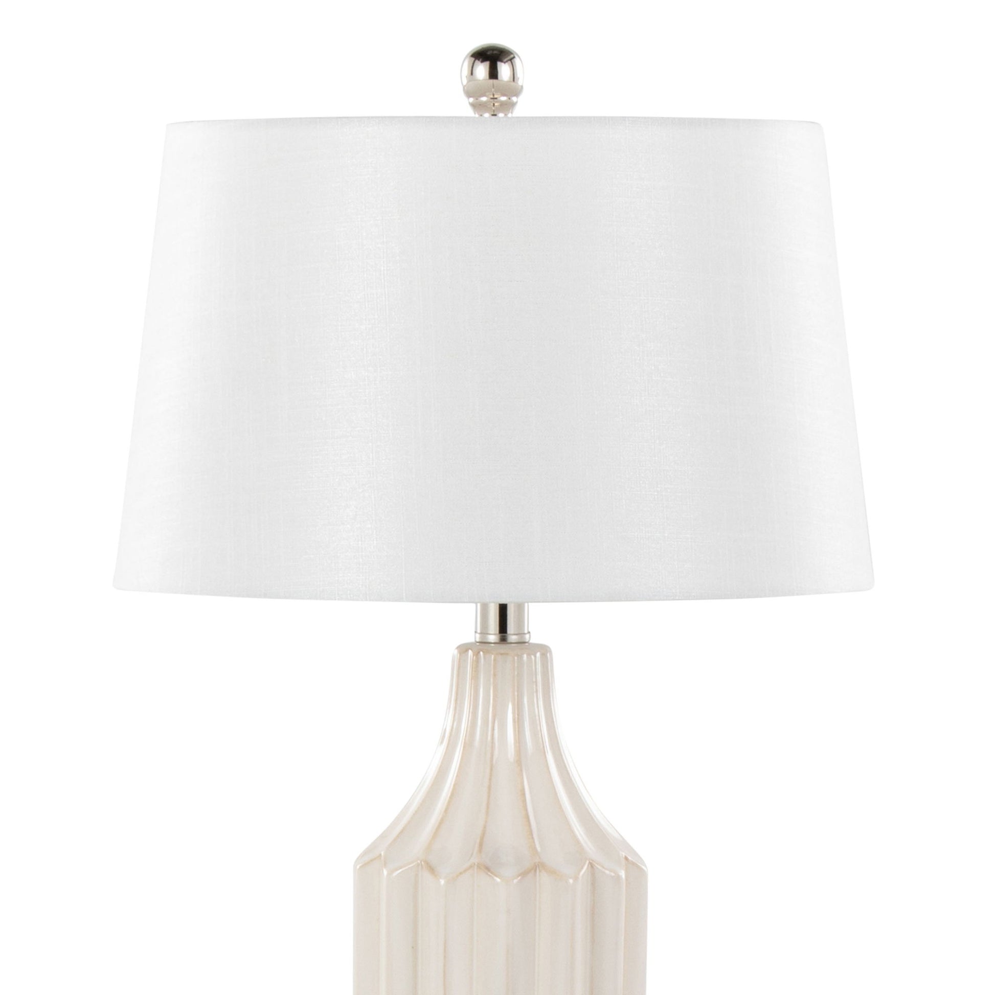 The Stella Contemporary Table Lamp features a beige ceramic base with vertical ridges, a white drum-shaped lampshade, and a silver finial for a stylish modern look.