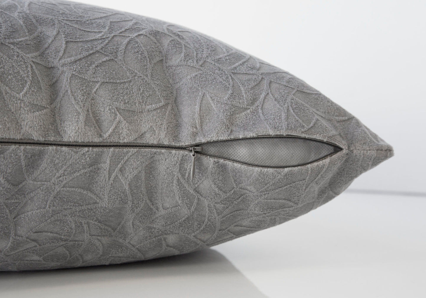 A close-up of the Pillow Square Decorative Throw shows its subtle gray leaf pattern and partially open side zipper against a plain white background; insert is included and it's hypoallergenic.