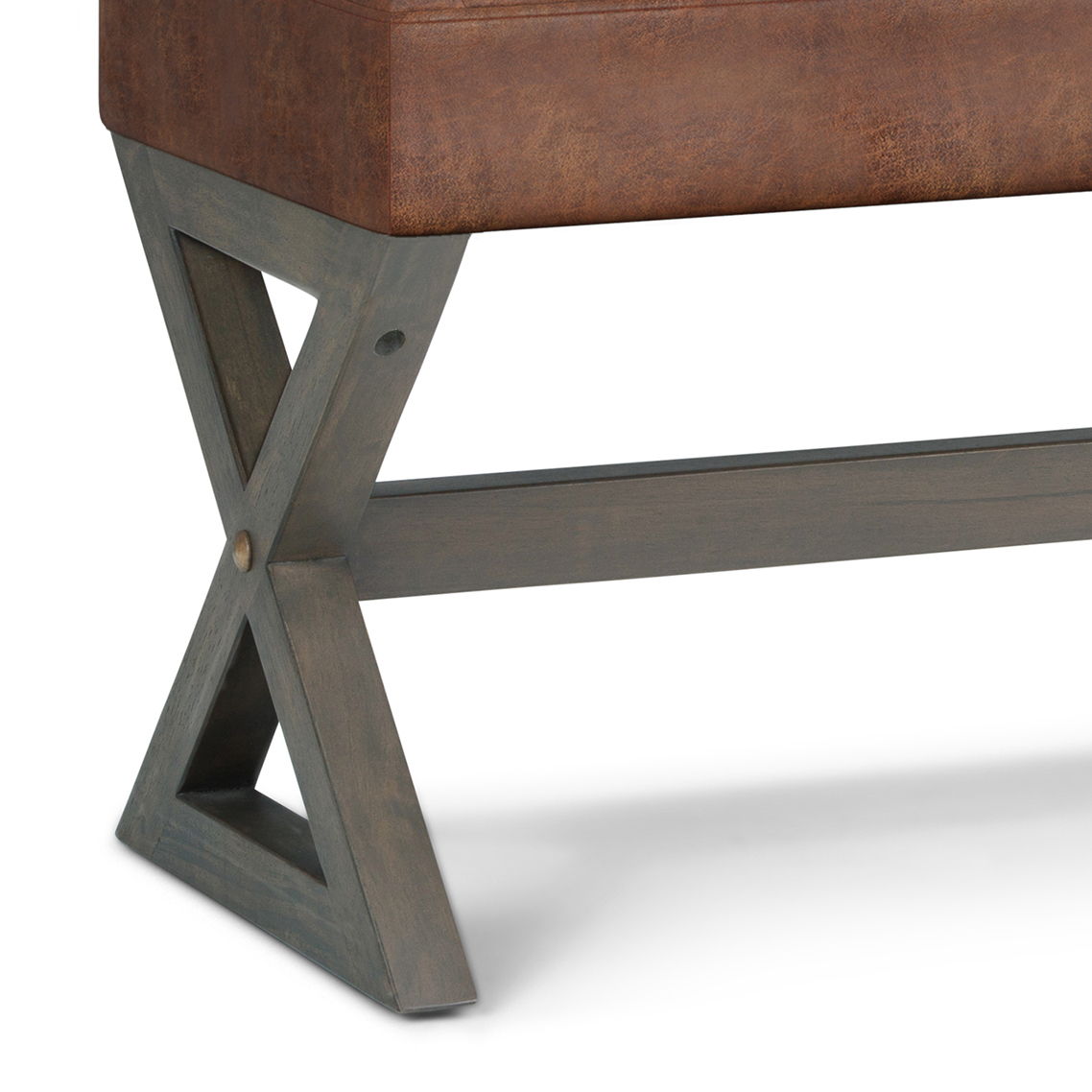 Close-up of the Salinger - Large Upholstered Ottoman Bench, featuring an X-shaped dark wood leg supporting a cushioned brown leather seat.