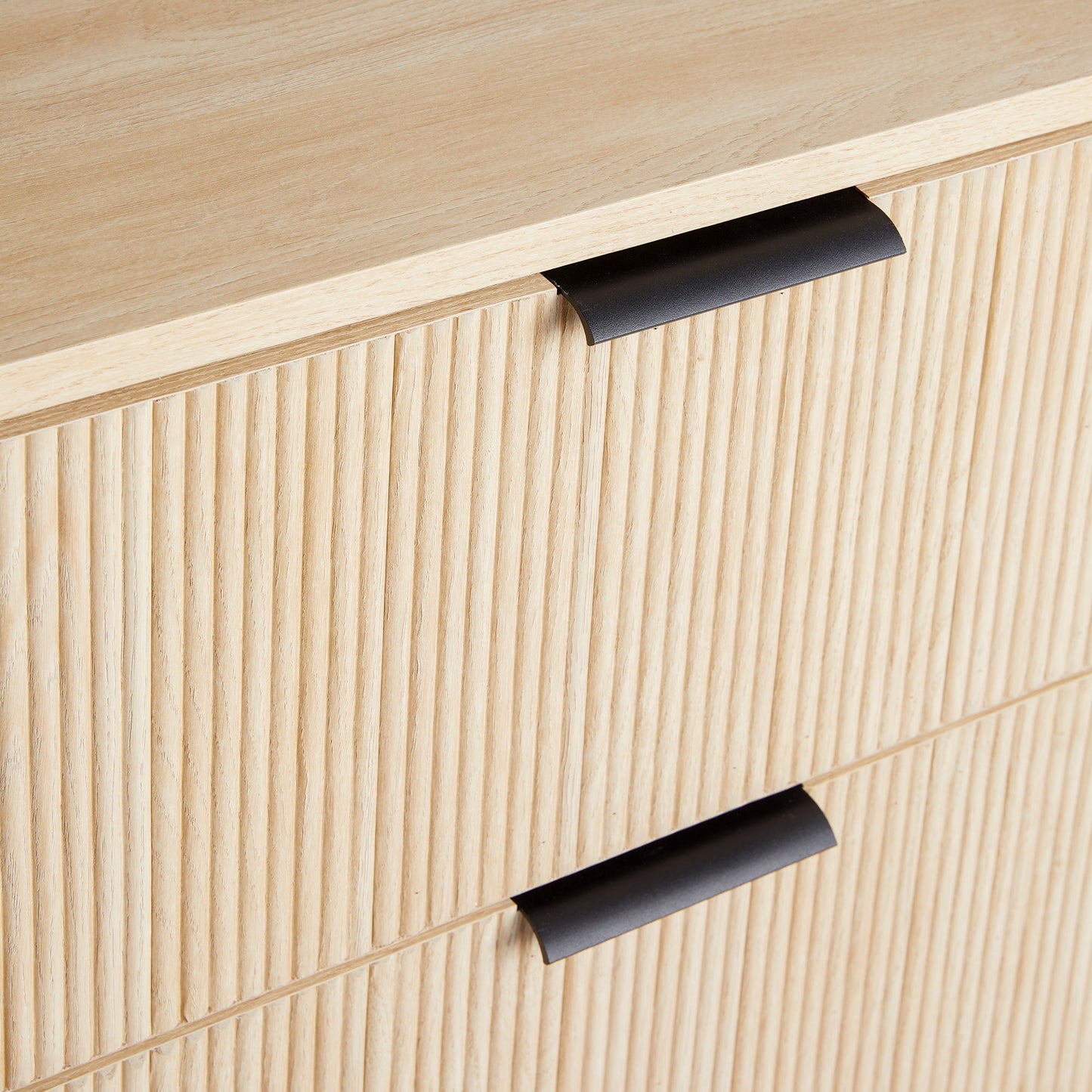 Close-up of the Mid-Century 3 Drawer Chest featuring reeded drawer fronts and modern black metal handles in light wood.