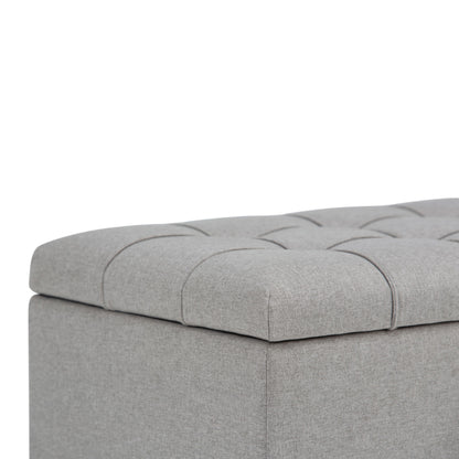 Close-up of the Sienna Upholstered Storage Ottoman Bench in light gray, featuring tufted fabric, visible stitching, and soft padding.