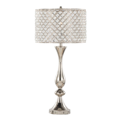 The Topaz - Contemporary Table Lamp features a tall, elegant design with a shiny silver base and a cylindrical lampshade decorated with diamond-patterned crystal accents.