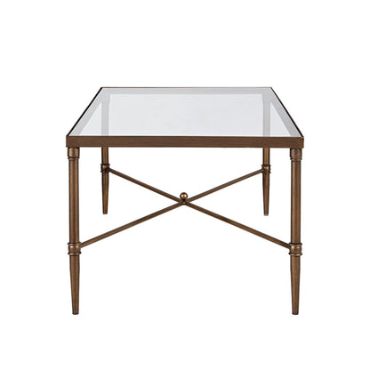 A bronze metal rectangle coffee table featuring a tempered glass top, four tapered legs, and an X-shaped crossbar with a round decorative center.