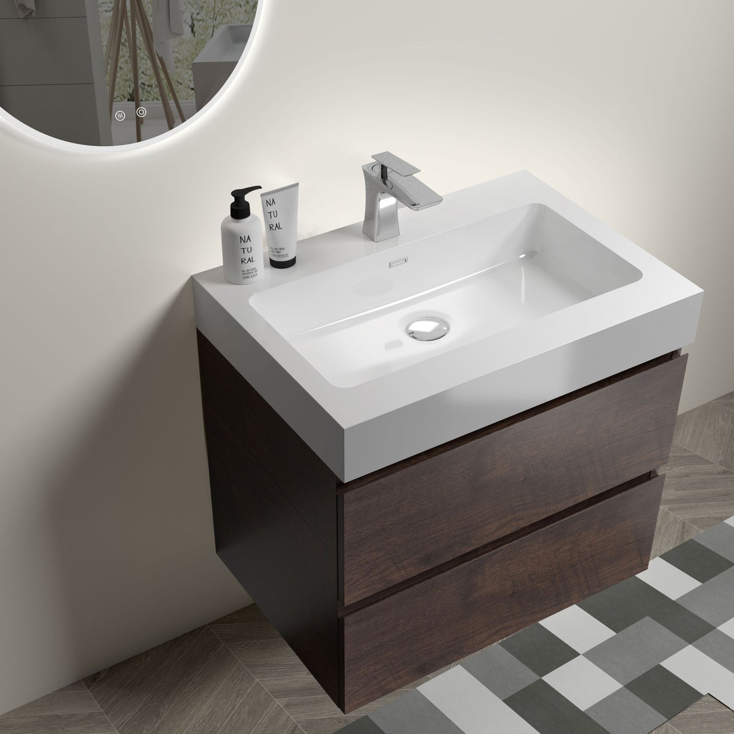 The Alice wall-mounted bathroom vanity features a modern rectangular white one-piece sink (no drain/faucet), large floating storage, and a sleek design. Geometric tile flooring enhances the look. Soap dispenser and bottle sit atop the counter.
