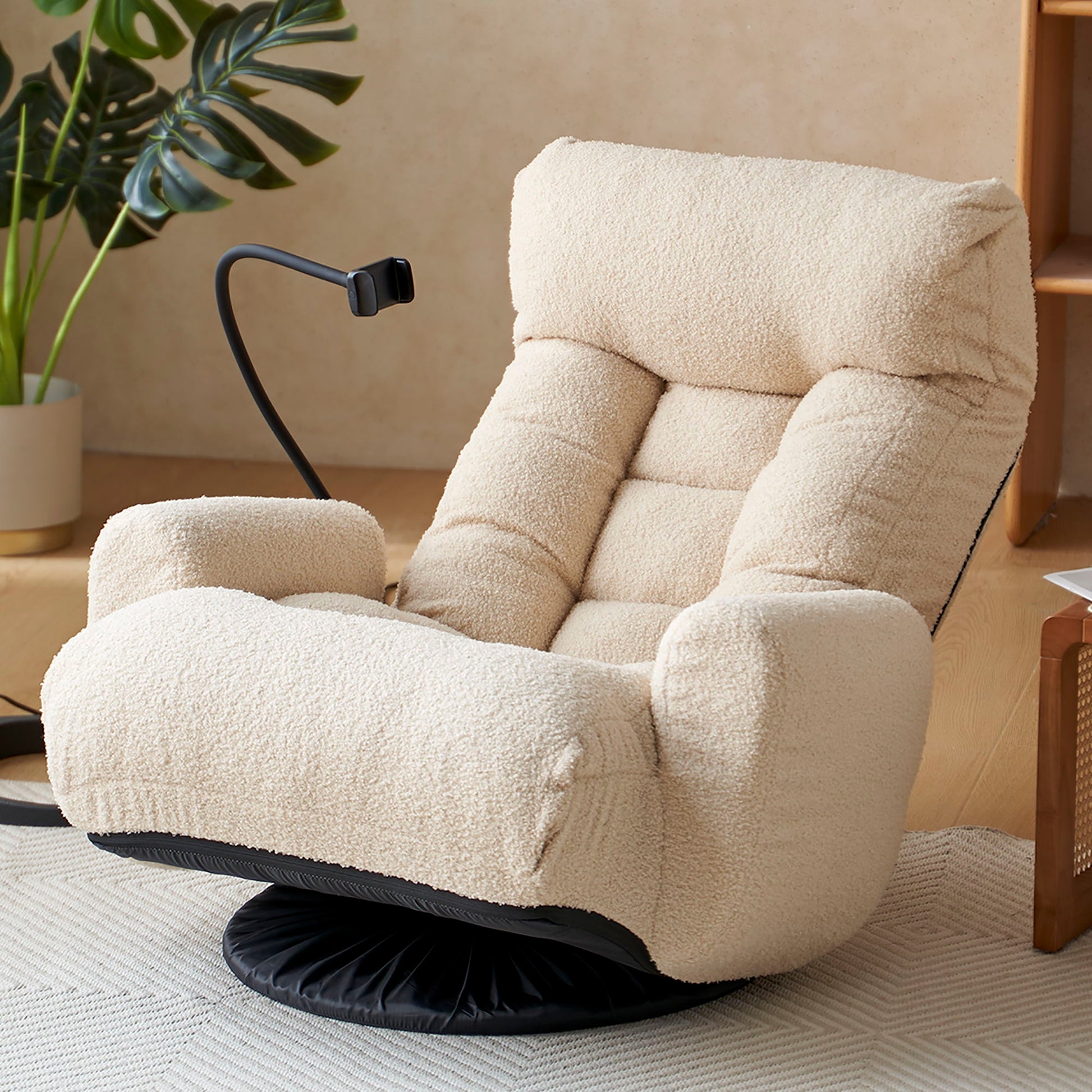 A cozy room features the Adjustable Swivel Lounge Chair with 360° rotating seat, headrest support, plush cream upholstery, tufted cushion, attached black reading light, and warm wooden accents beside a plant.