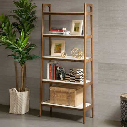 The Mid-Century Design 5 Shelf Bookcase in Off White/Pecan holds framed photos, decor, books, and baskets. A large potted plant in a woven basket stands beside it against a gray textured wall.