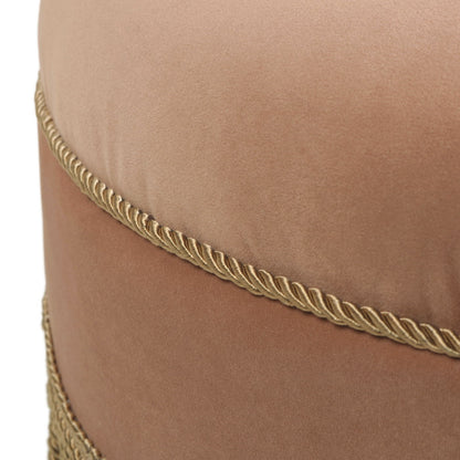 Close-up of the Yolanda Round Upholstered Accent Ottoman, featuring soft light brown velvet and two decorative gold braided cords wrapped horizontally.