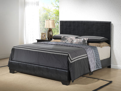 An Elegant Platform Bed For Relaxed Spaces with dark bedding and patterned pillows anchors a bright bedroom, complemented by a nightstand with a lamp, picture frame, and sheer white curtains in the background.