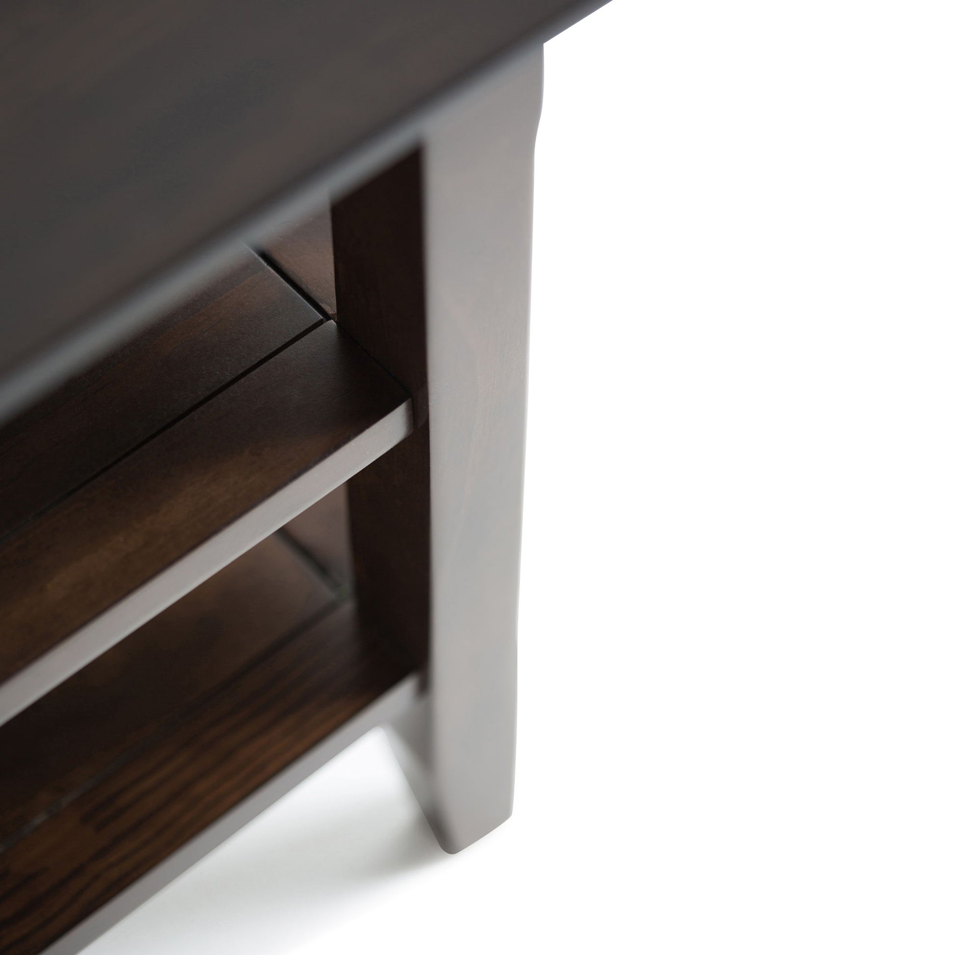 Close-up view of the Acadian - Handcrafted End Table in dark wood, showing its corner and visible lower shelf, set against a white background.