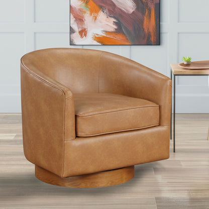 The Maisy - Barrel Swivel Chair in tan leather with a rounded back and wooden base sits on a light wood floor. In the background, there’s a modern abstract painting and a small table topped with a potted plant.