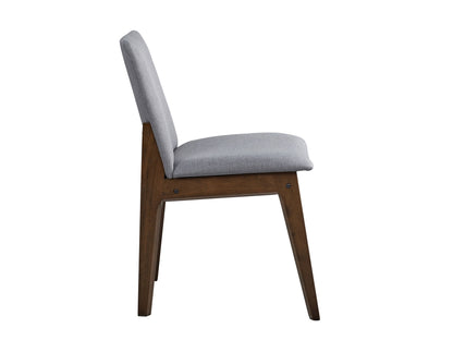 Side view of the Kaela Side Chair (Set of 2) in light gray, featuring a cushioned seat and backrest on an angled wooden frame with a dark brown finish.