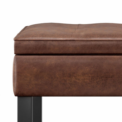 Close-up of the Cosmopolitan - Storage Ottoman Bench With Open Bottom, featuring a brown leather-cushioned seat with visible stitching and black metal legs, set against a white background.