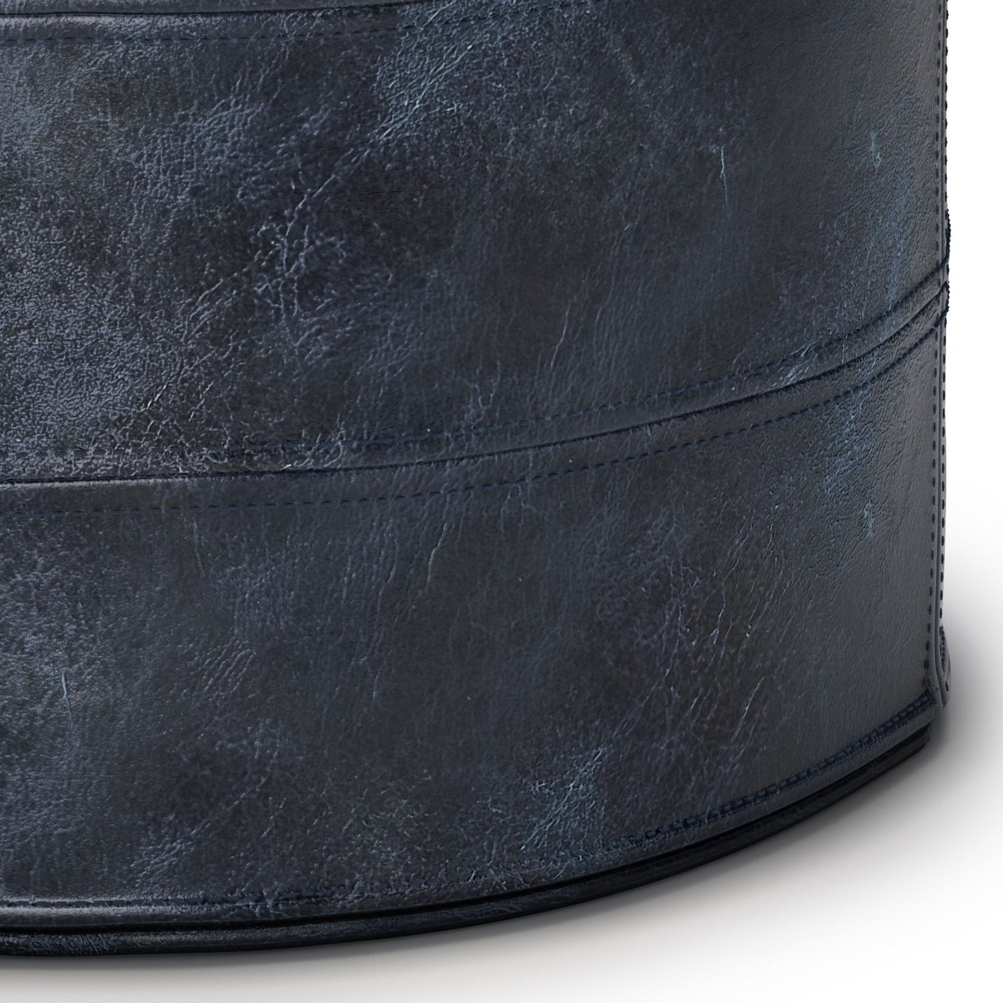 Close-up of the Connor - Handcrafted Round Pouf in dark blue, showcasing its textured, cylindrical form with visible stitching and a leather-like finish.