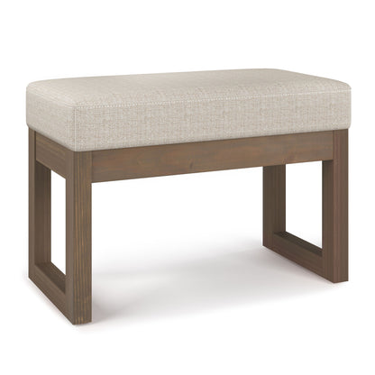 The Milltown Upholstered Ottoman Bench features a cushioned light beige seat and a wooden base with square, open legs in a dark brown finish. Its modern, minimalist design adds style and comfort to any space.