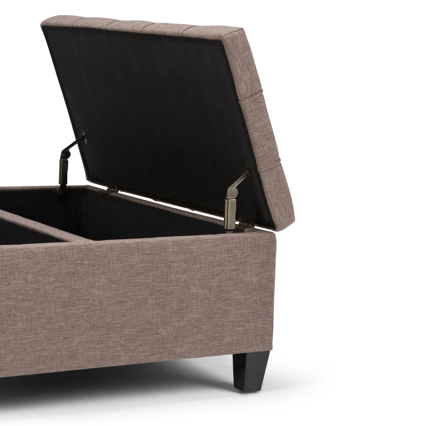The Harrison Upholstered Coffee Table Storage Ottoman features a padded, rectangular design with a hinged lid that opens to reveal storage space. It is upholstered in light brown fabric and stands on short black legs.