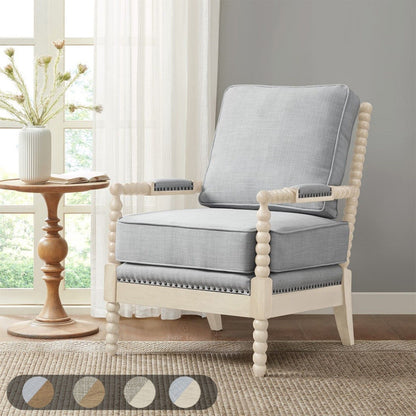 The Arm Chair With Open Back Spindle Design and padded armrests sits on a woven rug near a round side table with a vase. Sheer curtains cover the window in the background, and five neutral color swatches are displayed below.