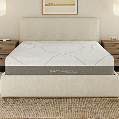A neatly made bed features the 12" Profile Massage Mattress Hybrid on a cream-colored upholstered frame, flanked by wooden nightstands and lit by wall sconces. A framed picture hangs above the headboard.